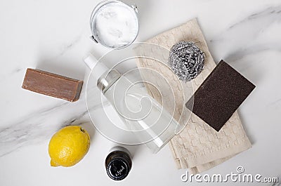 Top view of glass bottle of eco friendly washing product, natural soap, lemon, backing soda, scrubbers, towel on the white marble Stock Photo