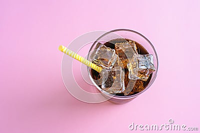 Top view of a glass of cola with ice cubes on pink background Stock Photo