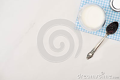 Top view of glass of homemade yogurt and teaspoon with blackberry on plaid fabric Stock Photo