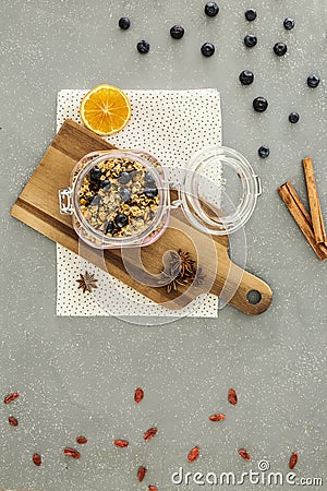 Top view on granola with berries on wooden desk next to orange. Stock Photo