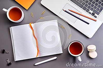 Top view of gray office desk with opened notebook or diary with blank page. Tea break with colleague or friend Stock Photo