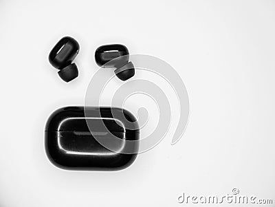 Top view grayscale of wireless earbuds with a black powerbank on an isolated background Stock Photo