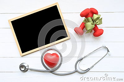 Top view of Green ribbon with dumbells and stethoscope of healthy heart and blackboard on wooden white background, Health care Stock Photo