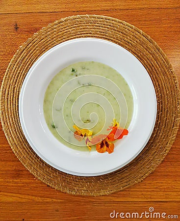 Top view of green soup with comestible flowers Stock Photo