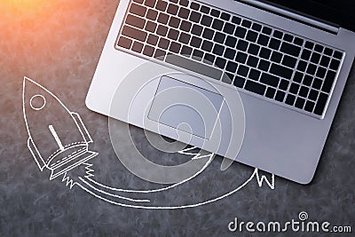 Top view of grey desktop with laptop keyboard, with creative rocket drawing. Business start up concept. Mock up Stock Photo