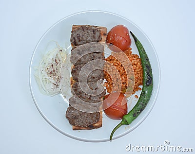 Top view of grilled meatballs, bulgur pilaf, roasted tomatoes and peppers served on white plate Stock Photo