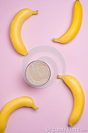Top view. Group of bananas and banana smoothie on pink background. Stock Photo