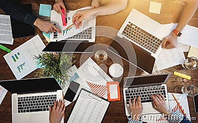 Top view of group business people sitting at table and using modern laptop, graphs and diagrams. Team of architecture are having a Stock Photo