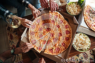 Top view of a group of friends eating big pizza Stock Photo