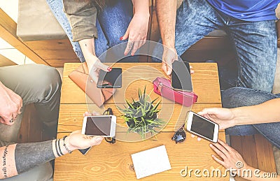 Top view of a group of hipster friends sitting in a bar cafe using mobile smart phone Stock Photo