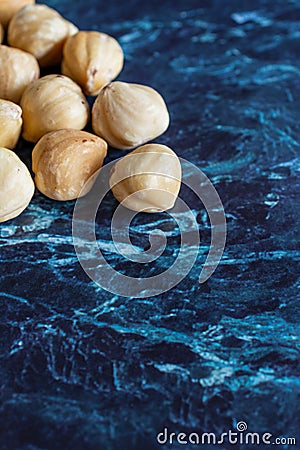 Top view of a group of peeled hazelnuts on blue marble background Stock Photo