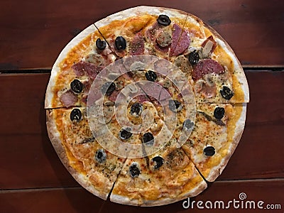 Half of Cubana and Neapolitan pizza on dark brown wooden table Stock Photo