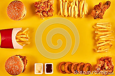 Top view hamburger, french fries and fried chicken on yellow background. Copy space for your text. Stock Photo