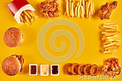 Top view hamburger, french fries and fried chicken on yellow background. Copy space for your text. Stock Photo