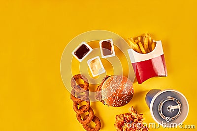 Top view hamburger, french fries and fried chicken on yellow background. Copy space for your text. Stock Photo