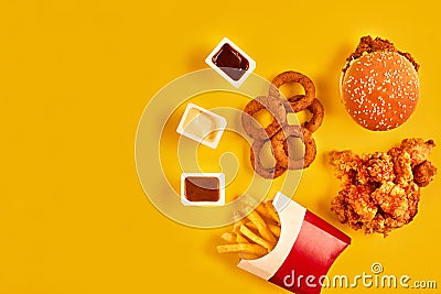 Top view hamburger, french fries and fried chicken on yellow background. Copy space for your text. Stock Photo