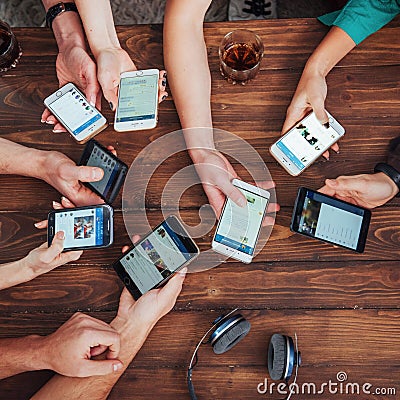 Top view hands circle using phone in cafe - Multiracial friends mobile addicted interior scene from above - Wifi Stock Photo