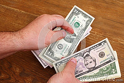 Top view of hands counting small dollar bills Stock Photo