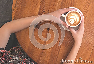 Top view of hands holding a cup of coffee. Stock Photo