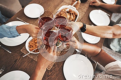 Top view, hands and toast with red wine at dinner table for new year celebration in home. Party, cheers and group of Stock Photo