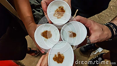 Top view of hands toasting with typical Peruvian drink: Pisco Sour Stock Photo