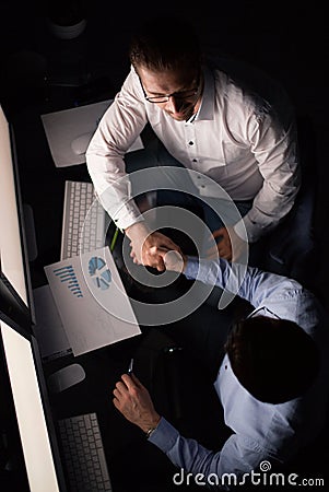 Top view.handshake employees at the Desk. Stock Photo