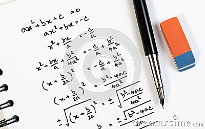 Top view of handwriting of mathematics quadratic equation formula on examination, practice, quiz or test in math class. Stock Photo