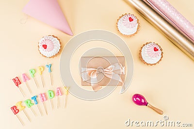 Top view of happy birthday lettering, envelope with ribbon and delicious cupcakes on pink Stock Photo