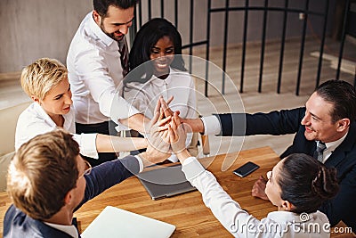 Business people join hands celebrating success Stock Photo