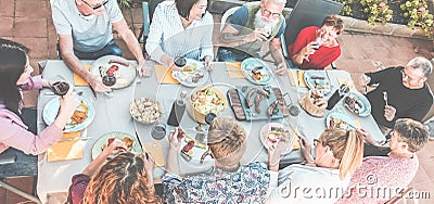 Top view of happy family eating and drinking wine at barbecue dinner outdoor - Multiracial people having fun at bbq sunday meal - Stock Photo