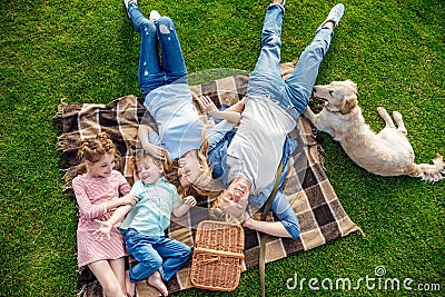 top view of happy young family with golden retriever dog resting on grass Stock Photo