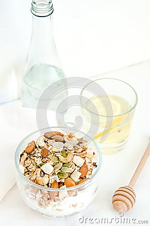 Top view healthy breakfast of homemade granola cereal with milk, strawberry, nuts and fruit, honey with drizzlier on Stock Photo