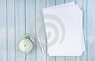 The Top view of heap empty A4 paper and vintage alarm on wooden background for your text or message Stock Photo