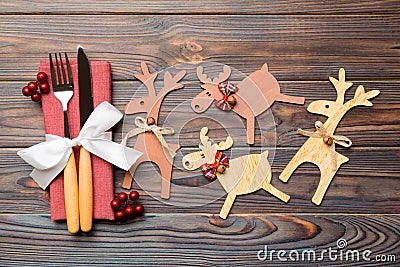 Top view of holiday objects on wooden background. Utensils tied up with ribbon on napkin. Close up of christmas decorations and Stock Photo