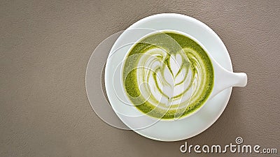 Top view of hot matcha green tea latte art foam beige color leather background Stock Photo