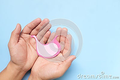 Top view of human hand holding stomach paper cutout. Stomach care, health, healthy digestion and ulcer prevention concept. Stock Photo