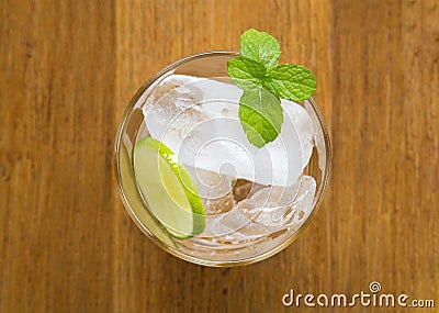 Top view of ice cubes in a glass with sliced lemon and fresh min Stock Photo