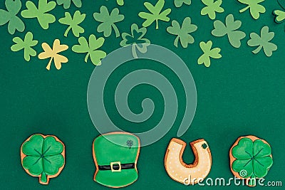 top view of icing cookies and paper shamrock isolated on green, st patricks day concept Stock Photo