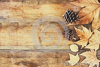 Top view image of autumn leaves and pine cones over wooden textured background Stock Photo