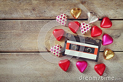 Top view image of colorful heart shape chocolates and audio cassette on wooden table. valentine's day celebration concept Stock Photo