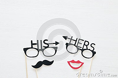 Top view image of funny photo booth props with text: HIS, HERS for party or wedding over white background. Stock Photo