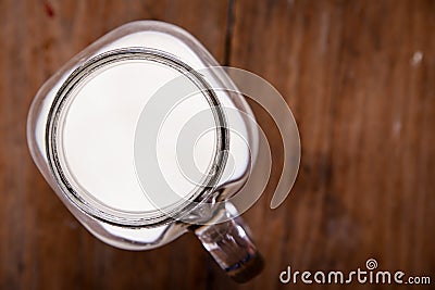 Top view image milk in a jug and a glass on wooden table. Stock Photo