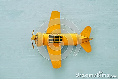 Top view image of retro yellow metal toy airplane over blue background. Stock Photo