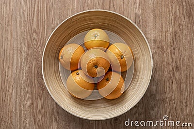 Top view image of round bamboo wood fruit bowl with Valencian oranges Stock Photo