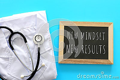 Top view image of table with blackboard and the text new mindset new results. Success and keeping health concept during covid 19 Stock Photo