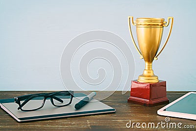 Top view imago of office table with the digital items golden Trophy. Business excellence concept. Stock Photo