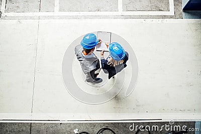 A top view of an industrial man and woman engineer with clipboard in a factory. Stock Photo
