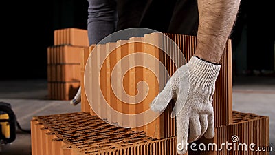 Top view of an industrial worker taking ceramic block at the construction site. Stock footage. Building new wall of Stock Photo
