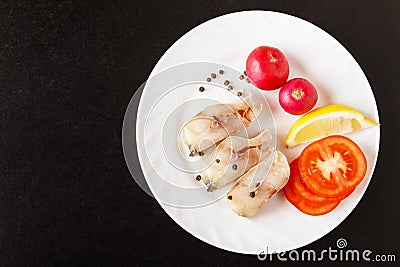 Top view on ingredients for cooking healthy dish. Steak fish, radish, lemon and tomatoes with pepper peas. Lunch or dinner menu. C Stock Photo