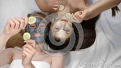 Top view on Joyful young girls friends having fun while doing cucumber mask in light beauty salon. Wellness, spa stock video footage Top view on Joyful young girls friends having fun while doing cucumber mask in light beauty salon. Wellness, spa stock video footage